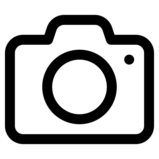 Black outline of a camera icon on a white background, featuring a central lens circle and a small dot in the upper right corner.